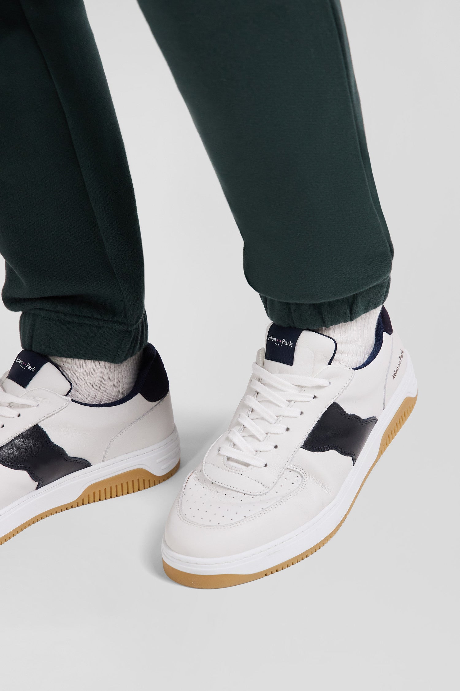 White low-top leather sneakers with navy blue cut-out