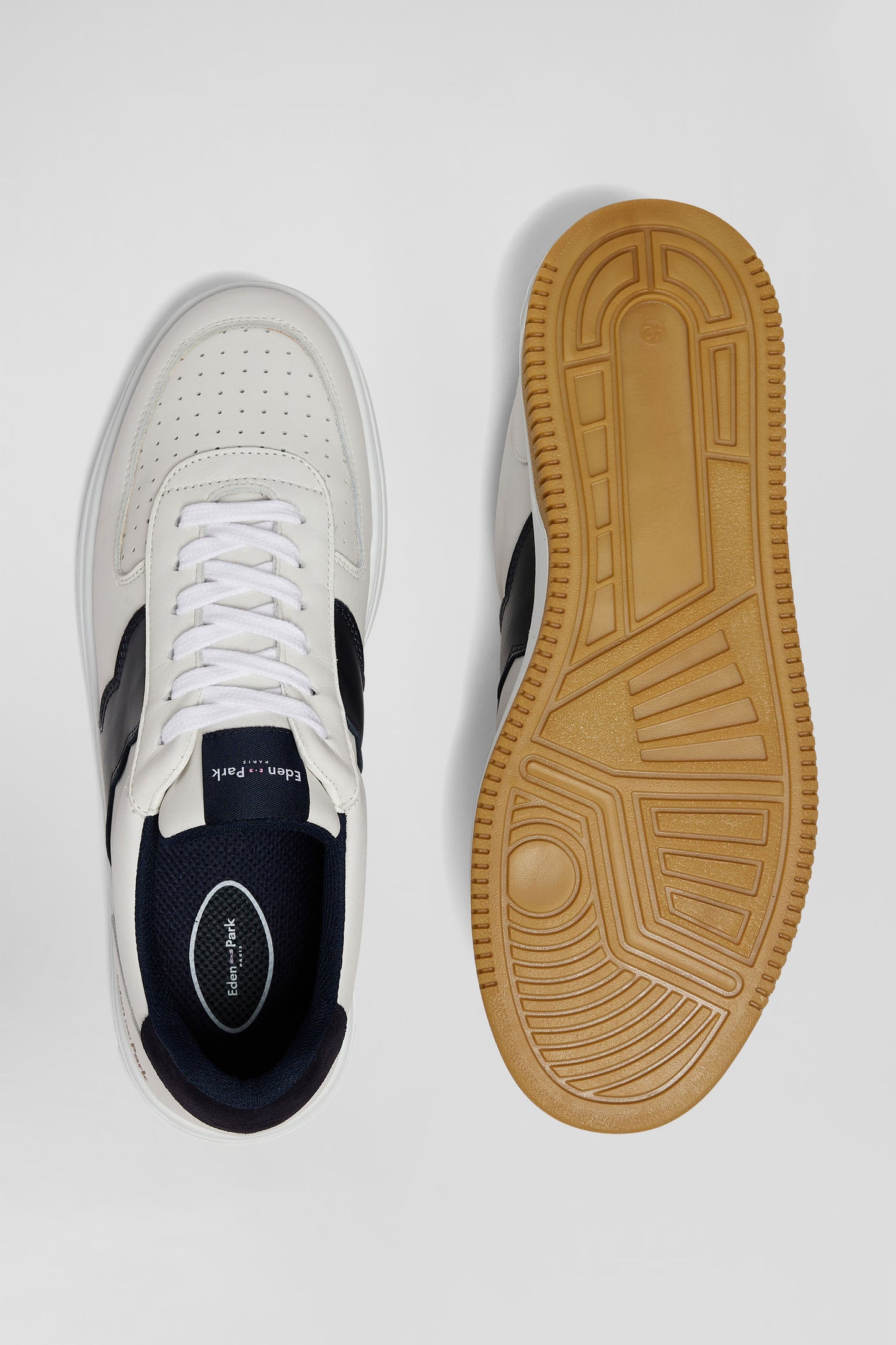 White low-top leather sneakers with navy blue cut-out